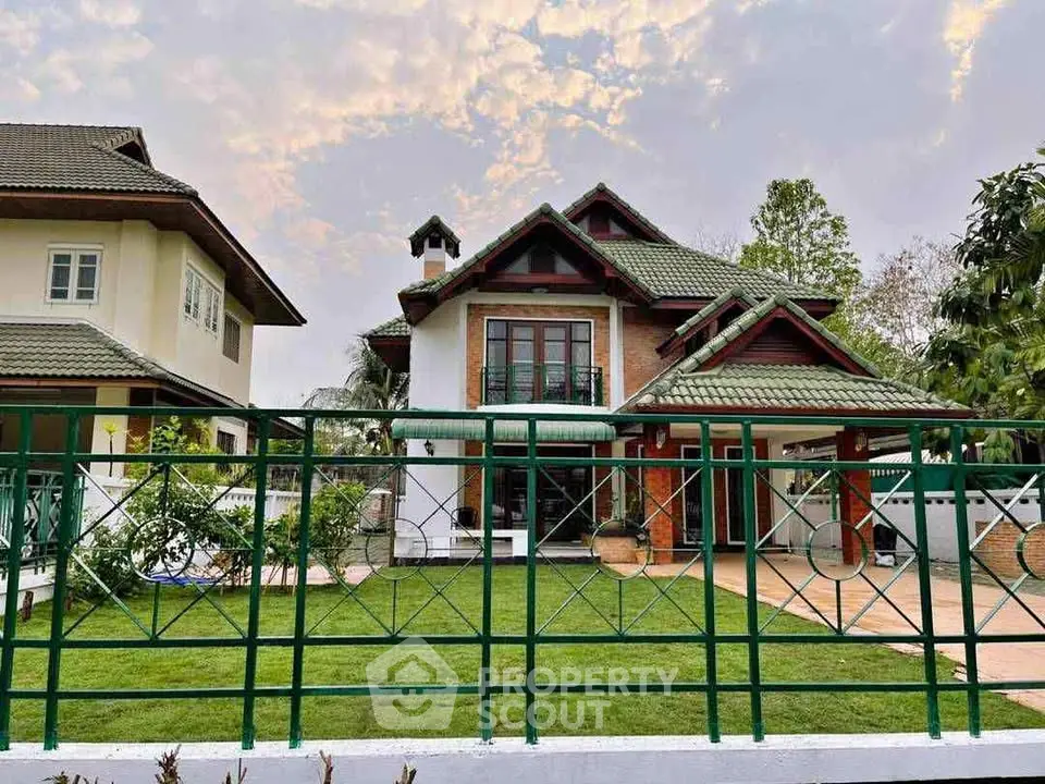 Charming two-story house with lush green lawn and elegant architectural design.