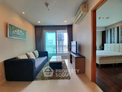Modern living room with city view, stylish decor, and adjacent bedroom in a high-rise apartment.