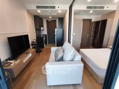 Modern studio apartment with open layout, featuring a cozy living area and sleek kitchen design.