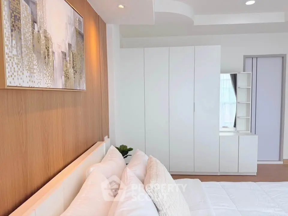 Modern bedroom with sleek white furniture and stylish wall art, perfect for a cozy and elegant living space.