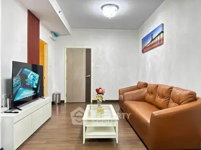 Modern living room with sleek furniture and wall art, featuring a cozy brown sofa and flat-screen TV.