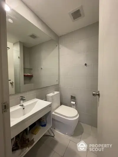 Modern bathroom with sleek fixtures and neutral tiles in a contemporary home.