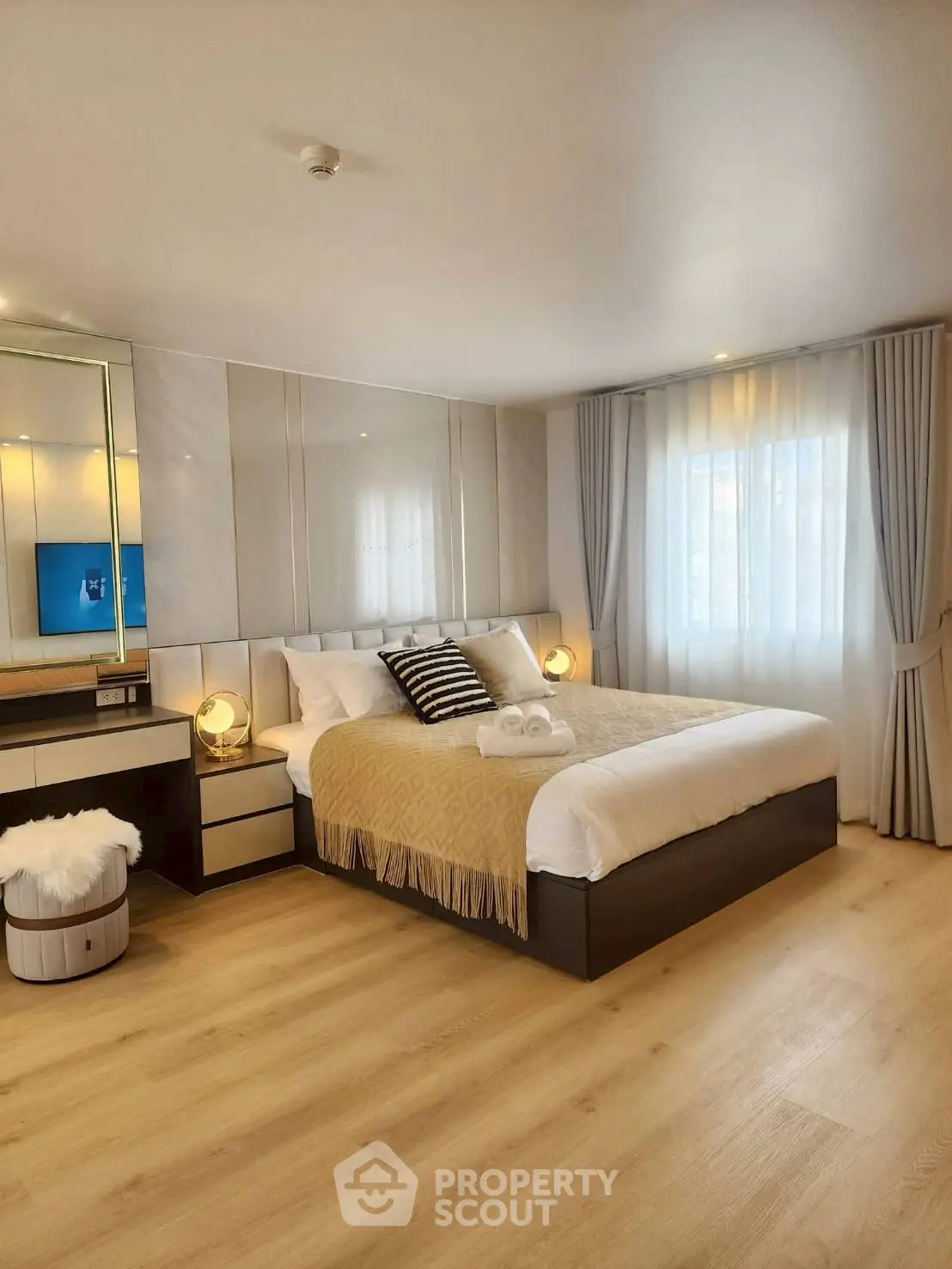 Luxurious bedroom with elegant decor and natural light, featuring a cozy bed and stylish furnishings.
