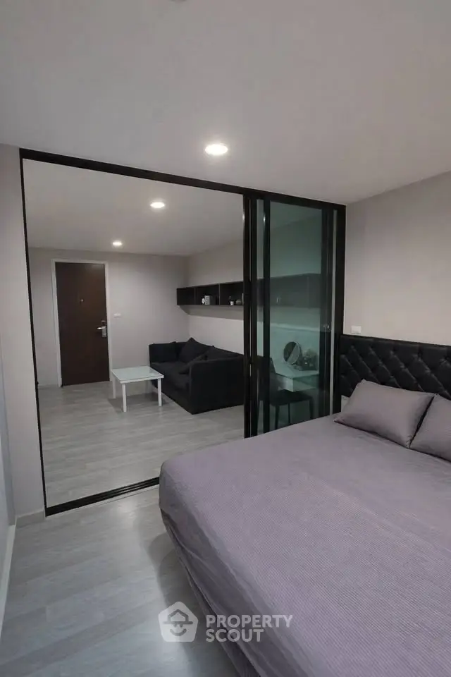 Modern bedroom with glass partition and cozy living area