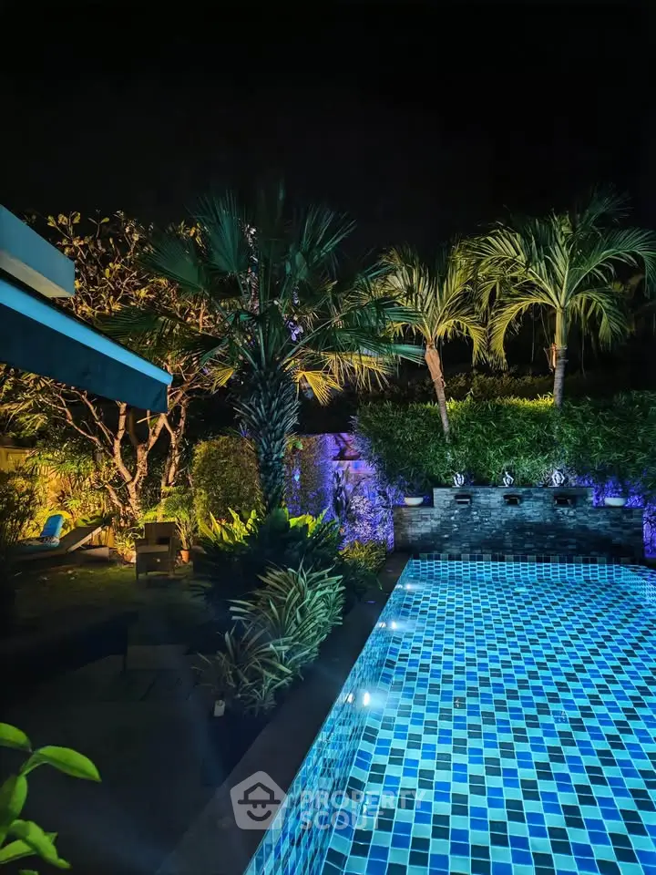 Luxurious night view of a private pool surrounded by lush tropical greenery, perfect for relaxation and entertainment.