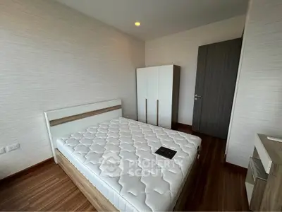 Modern bedroom with sleek furniture and wooden flooring, perfect for a cozy living space.