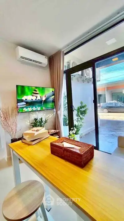 Modern living room with large window, air conditioning, and stylish decor