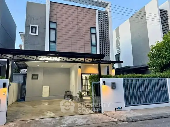 Modern two-story house with sleek facade and gated driveway in a suburban neighborhood.