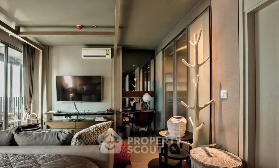 Modern living room with stylish decor and large TV, featuring a cozy seating area and elegant lighting.