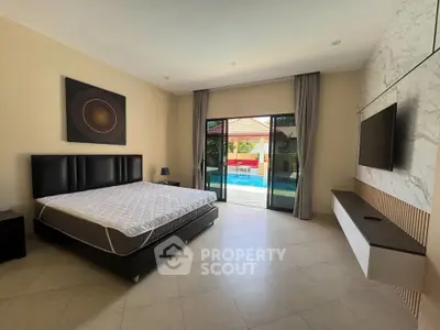 Spacious bedroom with pool view, modern decor, and large windows for natural light.