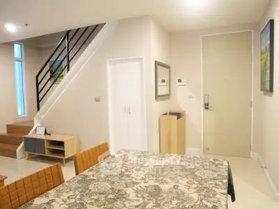 Modern interior with dining area and staircase in stylish apartment