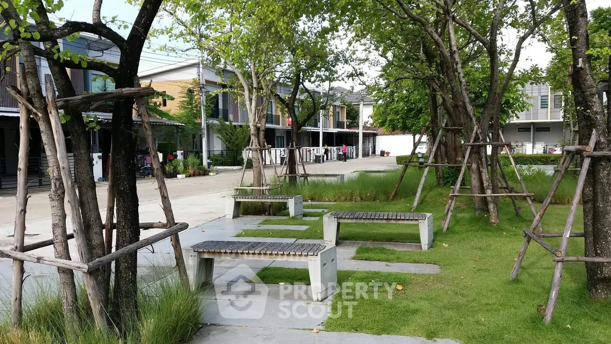 Charming residential community with lush green park and modern townhouses.