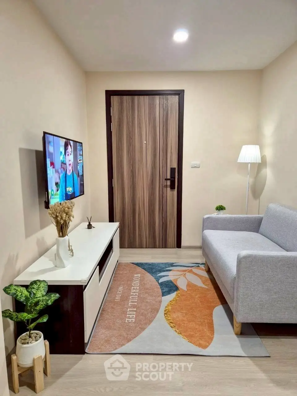 Cozy living room with modern decor and wall-mounted TV, perfect for relaxation.