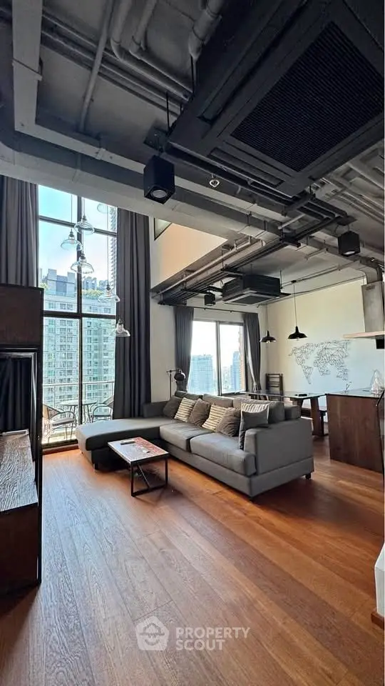 Spacious modern living room with high ceilings and city view, featuring stylish furniture and open layout.