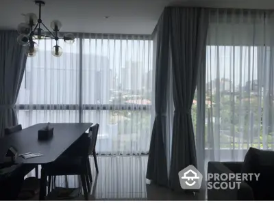 Modern dining area with large windows offering city view and elegant curtains