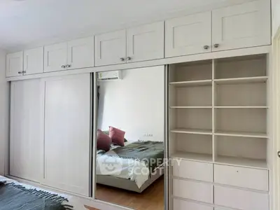 Spacious bedroom with built-in wardrobe and mirrored sliding doors, offering ample storage and modern design.