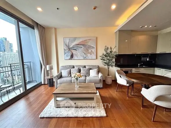 Modern living room with open kitchen and city view balcony in luxury apartment.