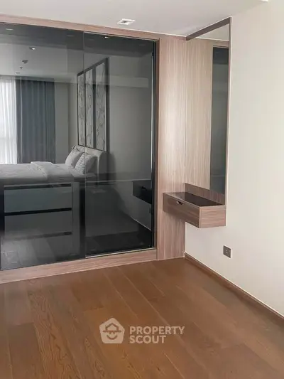 Modern bedroom with wooden flooring and mirrored wardrobe