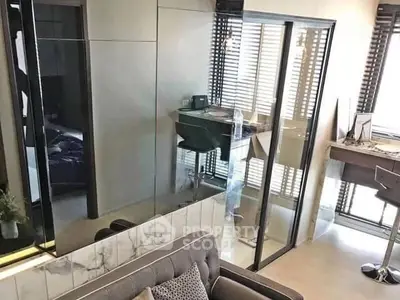 Modern living room with glass partition and stylish decor in a contemporary apartment.