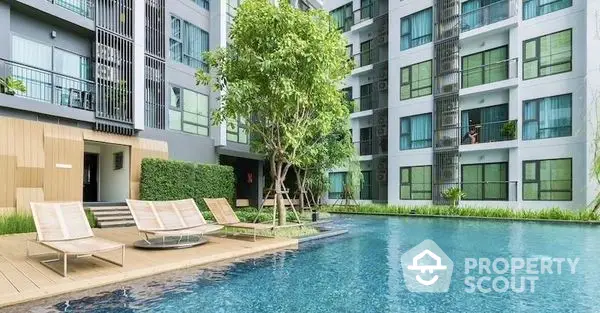 Luxurious residential complex with a sparkling blue communal pool surrounded by lush greenery and modern lounging chairs, offering a serene oasis for relaxation and socializing.