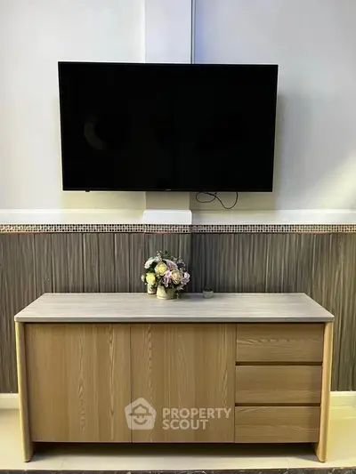 Modern living room with mounted TV and stylish wooden cabinet