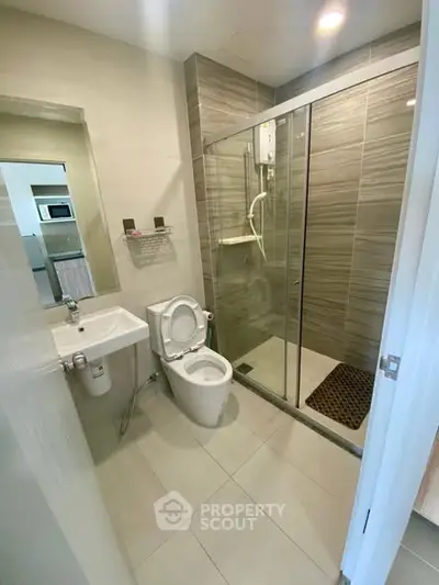 Modern bathroom with glass shower and sleek fixtures in a contemporary apartment.