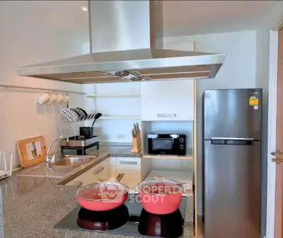 Modern kitchen with sleek appliances and granite countertops in a stylish apartment.