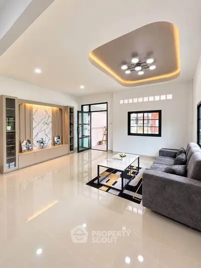 Modern living room with sleek design, featuring a stylish ceiling light, elegant marble accent wall, and cozy gray sofa.