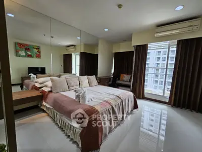 Spacious bedroom with modern decor and large windows offering city views.