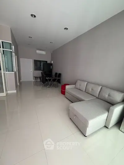 Spacious modern living room with sleek furniture and dining area, perfect for contemporary living.