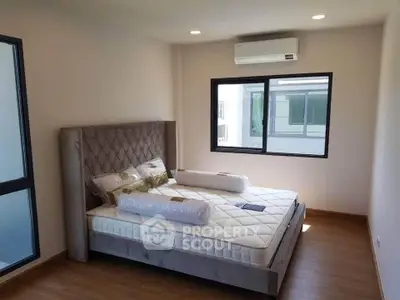 Spacious bedroom with modern design and large windows for natural light.