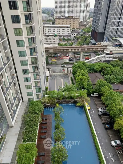 High-rise apartment view with pool and lush greenery in urban setting.