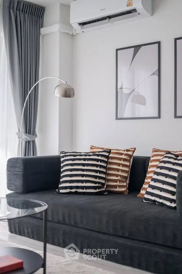 Modern living room with stylish sofa, abstract art, and elegant floor lamp