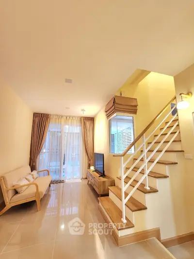Modern living room with elegant staircase and cozy seating area