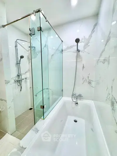 Luxurious bathroom with marble tiles and modern shower and bathtub setup