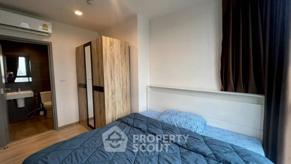 Cozy bedroom with modern decor and ensuite bathroom in a stylish apartment.