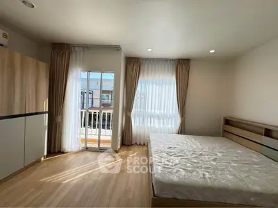 Spacious bedroom with natural light and balcony access in modern apartment