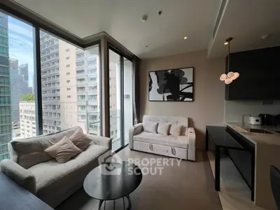 Modern living room with large windows and city view, featuring stylish furniture and contemporary decor.