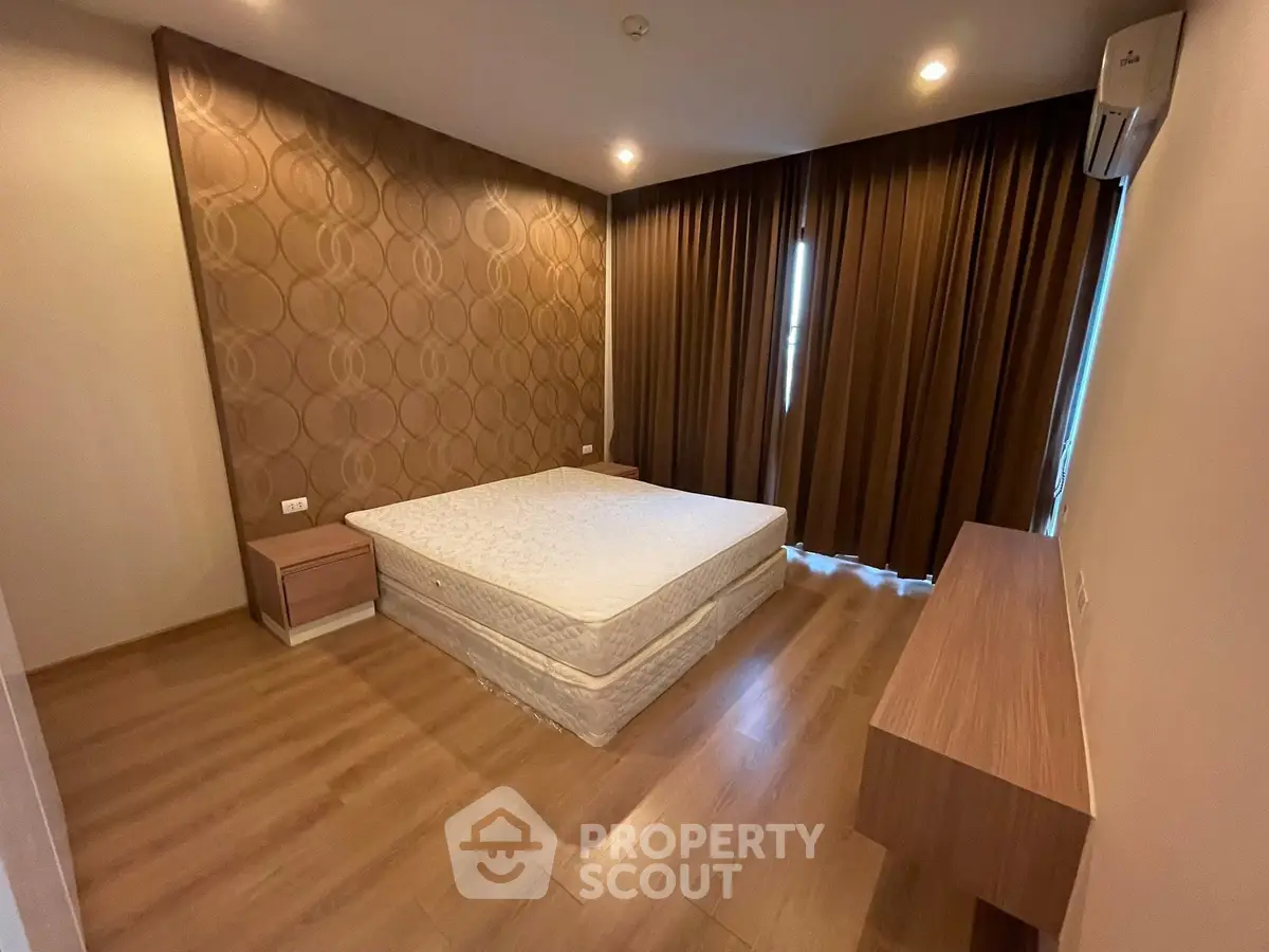 Spacious bedroom with modern decor and wooden flooring