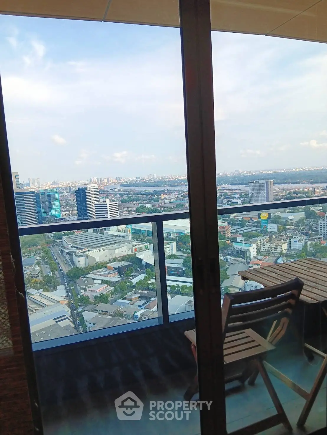 Stunning high-rise balcony view overlooking cityscape with clear skies and modern buildings.