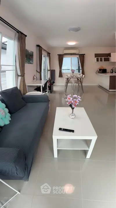 Modern living room with sleek furniture and open kitchen layout, perfect for contemporary living.