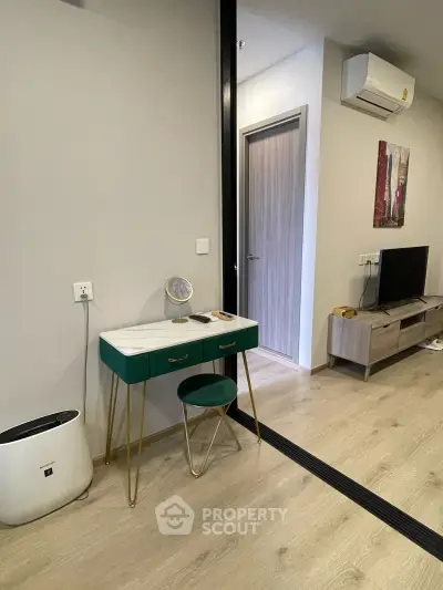 Modern apartment interior with stylish vanity, air conditioning, and sleek TV setup.