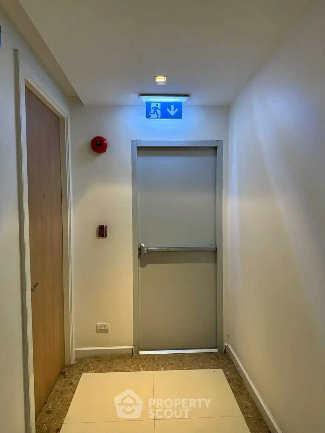 Modern building hallway with emergency exit door and safety features.
