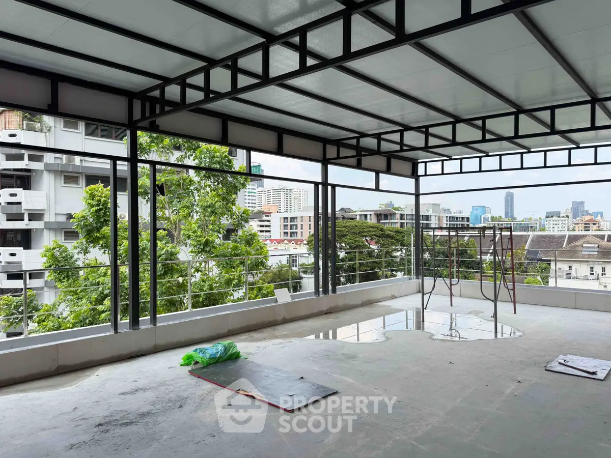 Spacious under-construction balcony with city skyline view, perfect for customization and outdoor relaxation.