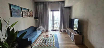 Modern living room with stylish decor and balcony view in urban apartment.
