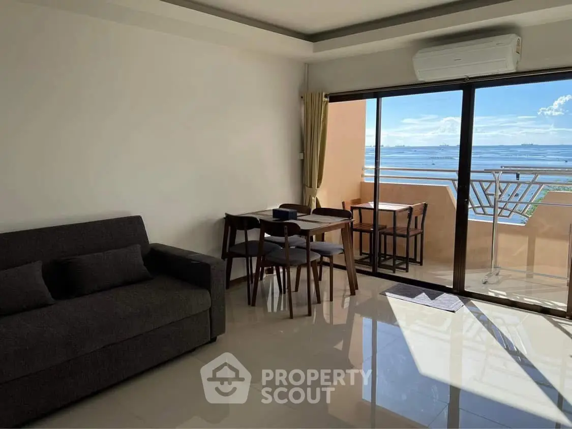 Modern living room with balcony and stunning sea view, featuring sleek furniture and air conditioning.
