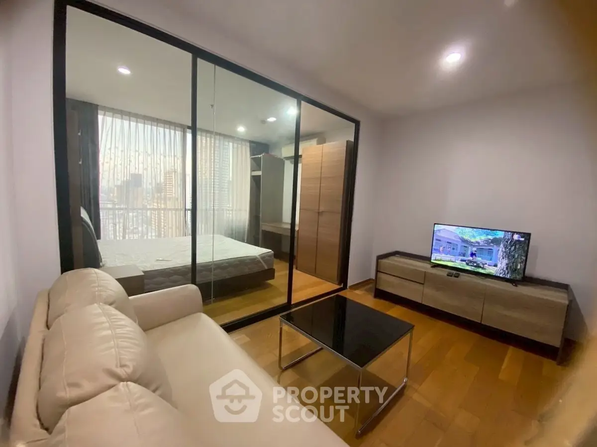 Modern apartment with glass-walled bedroom and cozy living area