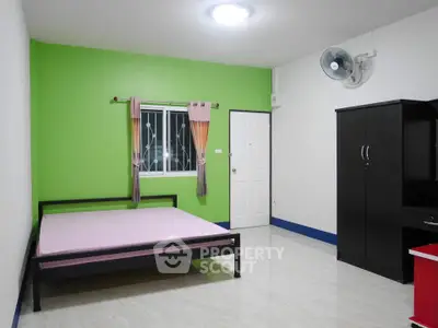 Spacious bedroom with vibrant green accent wall and modern furnishings