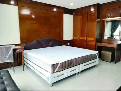 Spacious bedroom with elegant wooden furnishings and large bed