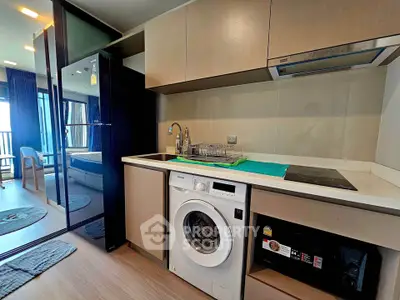 Modern kitchen with washing machine and sleek cabinetry in a stylish apartment